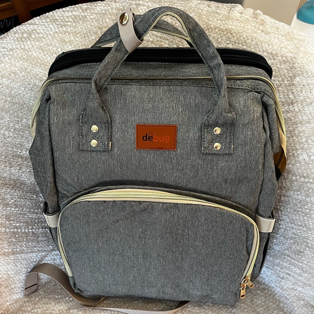 Never been used Debug grey diaper bag.  Comes with a portable changing table